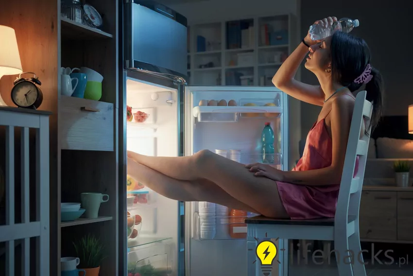 Kobieta chłodzi się przed lodówką