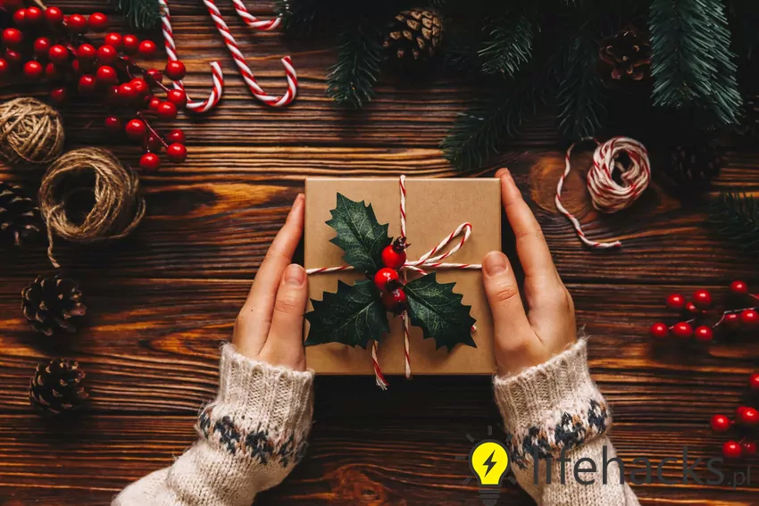 Postaw na jakość zamiast ilości – lepiej wręczyć jeden dobrze przemyślany prezent niż kilka przypadkowych drobiazgów Prezent trzymany w dłoniach
