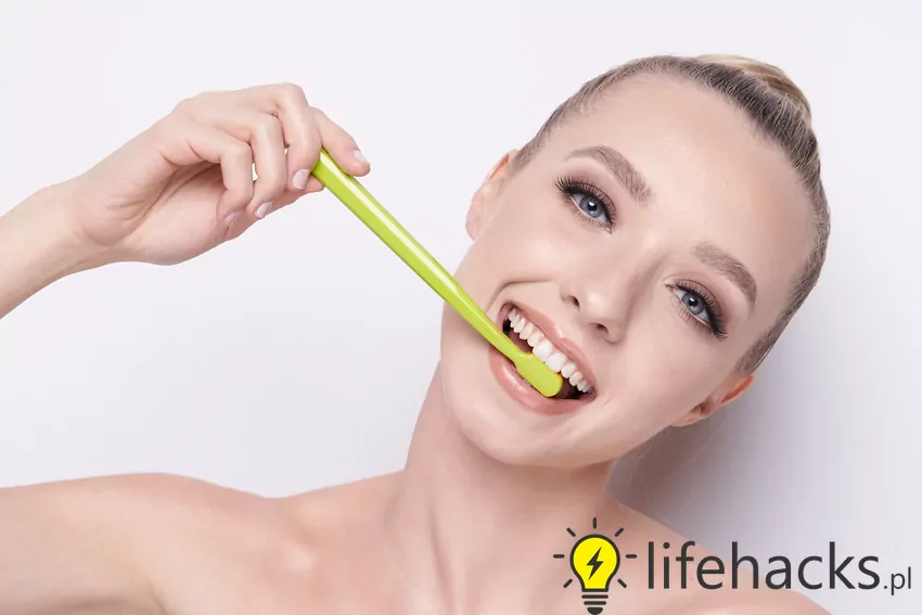 Stosuj regularnie irygator do zębów, który pomaga wypłukać resztki jedzenia i bakterie Kobieta ze szczoteczką do zębów